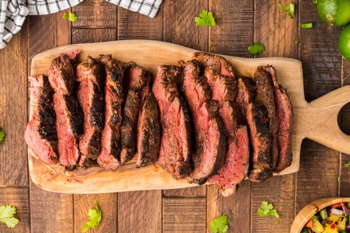 Sliced blackened steak on a cutting board.