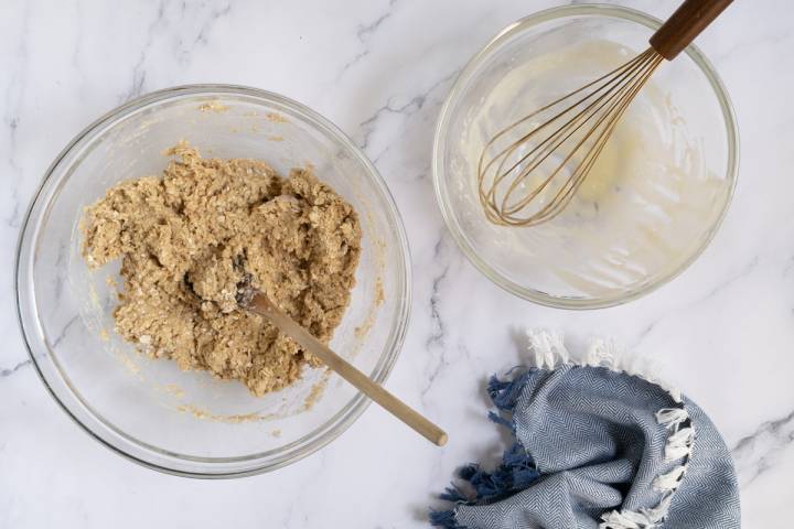 Oatmeal dough being stirred in a glass bowl.