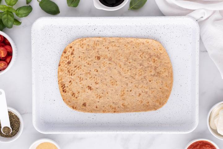 Plain flatbread on a baking sheet.