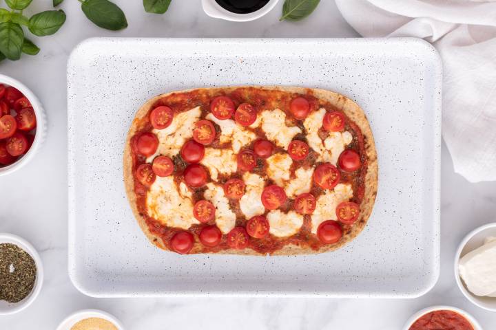 Baked flatbread with marinara sauce, cherry tomatoes, and melted mozzarella cheese.