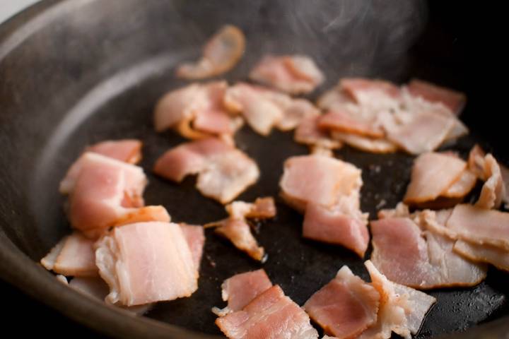 Bacon cooking in a skillet.