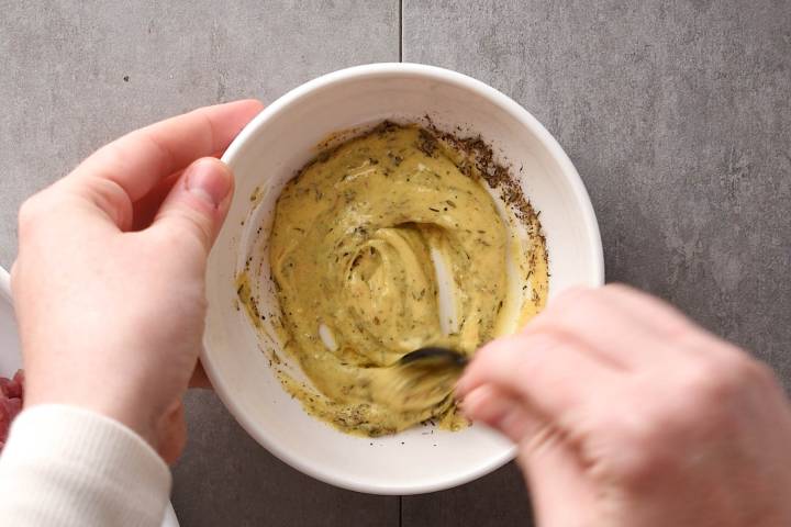 Mustard, thyme, salt, and pepper in a bowl.