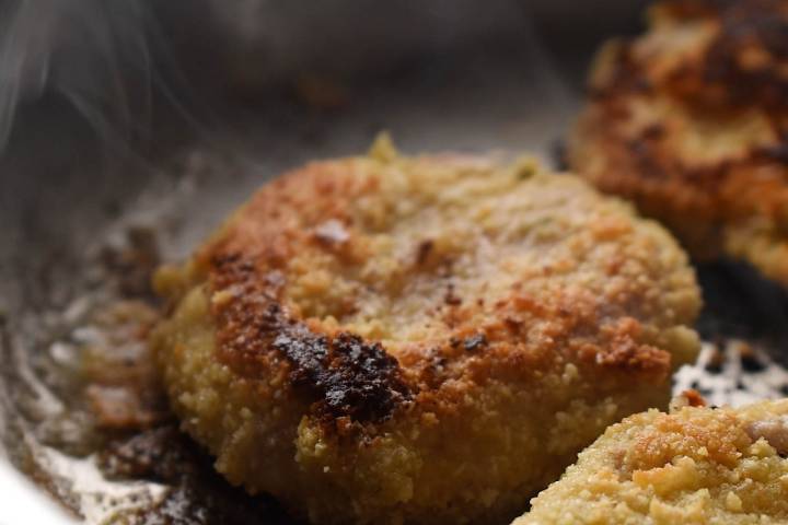 Almond breaded pork being fried in a skillet.