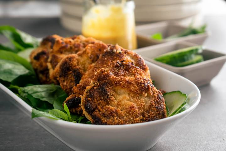 Crispy almond pork chops on a plate with greens.