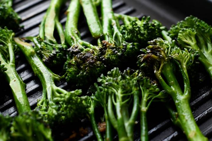 Broccolini on a griil pan with charred edges.