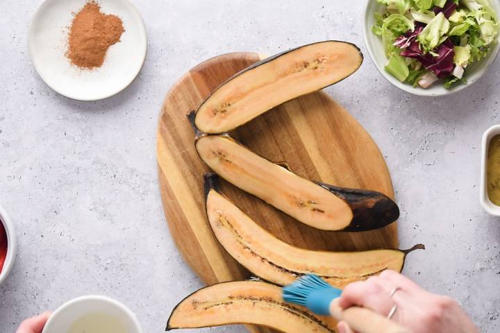 Plantains being brushed with coconut oil.