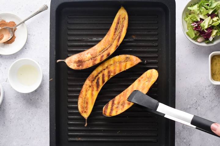 Ripe plantains being cooked on a grill pan.