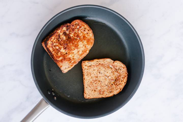 Whole grain French toast  cooking in a skillet.