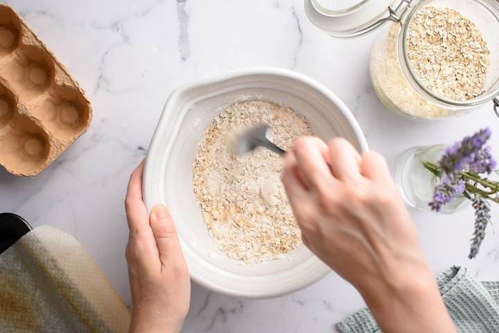 Oatmeal, flour, baking soda, baking powder, cinnamon, and nutmeg in a bowl.