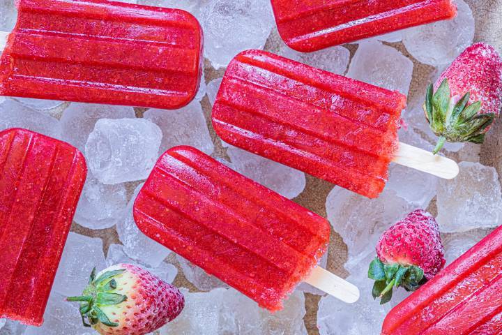 Frozen strawberry popsicles on ice cubes. 