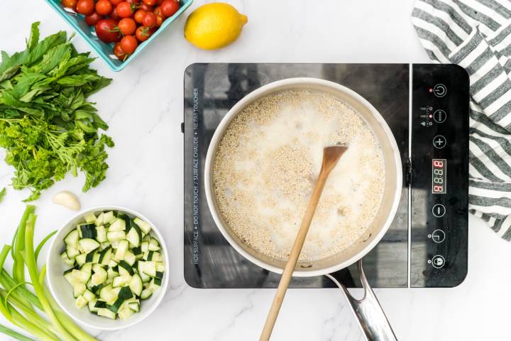 Quinoa cooking in a pot on an induction burner.