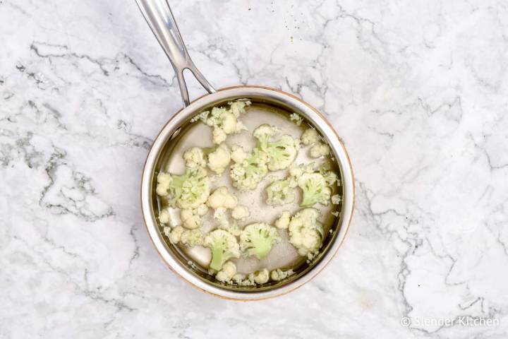 Cauliflower cooking in a pot of boiling water.