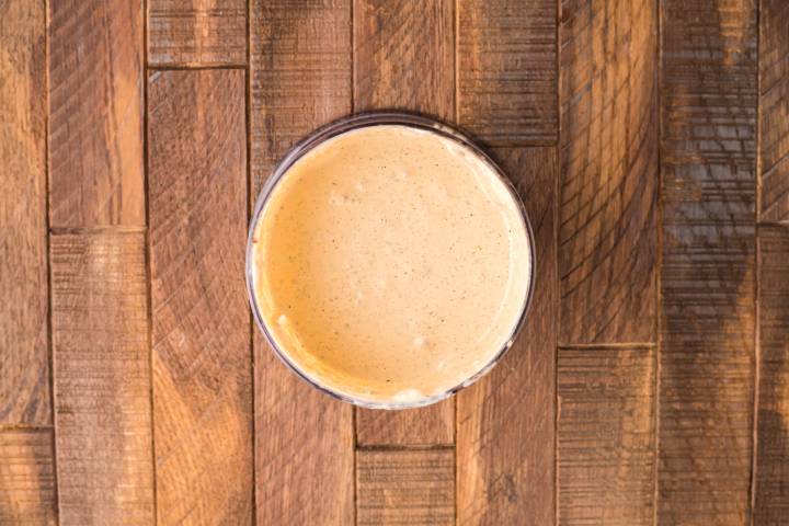 Southwest salad dressing in a glass jar on a wooden surface.