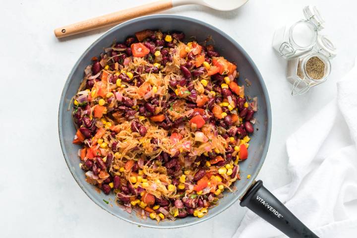 Spaghetti squash, red beans, corn, salsa, and spices in a skillet.