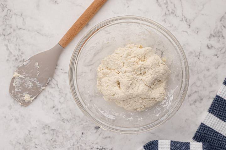 Greek yogurt and self rising flour mixed together to make dough in a bowl.