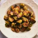 Brussel sprouts that have been roasted in a white bowl.