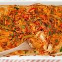 Chicken fajita casserole baked in a dish with peppers, onions, chicken breast, and melted cheese.