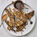 Grilled bananas on a plate with peanut butter, chocolate, and cinnamon. 