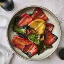 Grilled peppers with red, green, and yellow peppers with balsamic glaze on a plate.