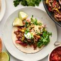 Ground beef fajitas with seasoned beef, bell peppers, onions, cilantro, cheese, and sour cream on flour tortillas.