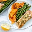 Sheet pan salmon with green beans and butternut squash served with a lemon and mustard sauce on a plate.