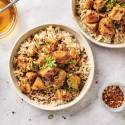 Slow cooker honey garlic chicken with green onions over a bed of brown rice