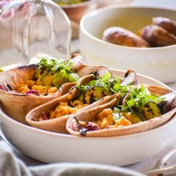 Veggie tacos tacos with mushrooms, corn, and zucchini in a wheat taco shell in a bowl. 
