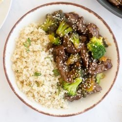 Healthy beef and broccoli served on a plate with steamed rice.