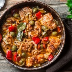 Slow Cooker Mediterranean Chicken with roasted red peppers, olives, capers, and more in a skillet.