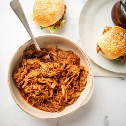 Slow cooker spicy pulled pork with shredded pork tenderloin in spicy barbecue sauce in a bowl.