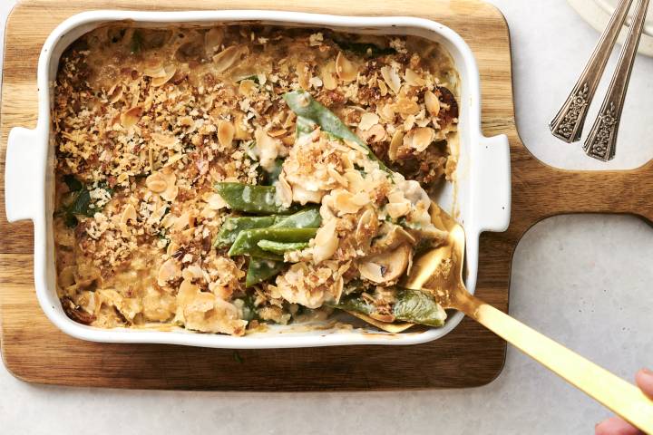 Green bean casserole in a dish, being served with a spoon.