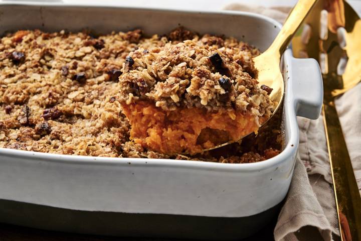 Healthy sweet potato casserole being served with a spoon.