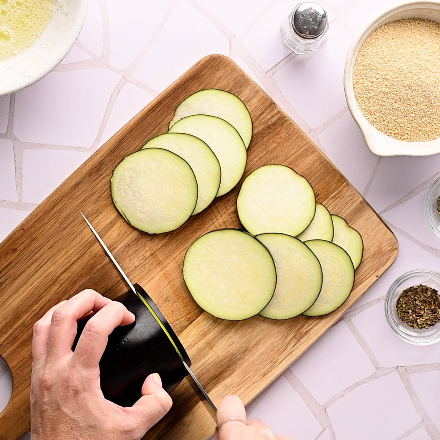 Cutting eggplant slices into bread … – License image – 10173092