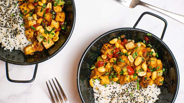 Kung Pao Tofu with celery, red peppers, and peanuts in a dish with white rice.