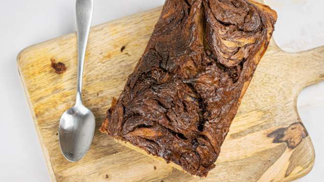 Nutella banana bread with swirls of nutella and banana on a wooden cutting board.