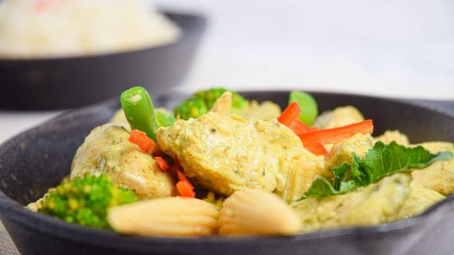 Slow Cooker Thai Curry Chicken with vegetables and curry sauce in a bowl with rice.