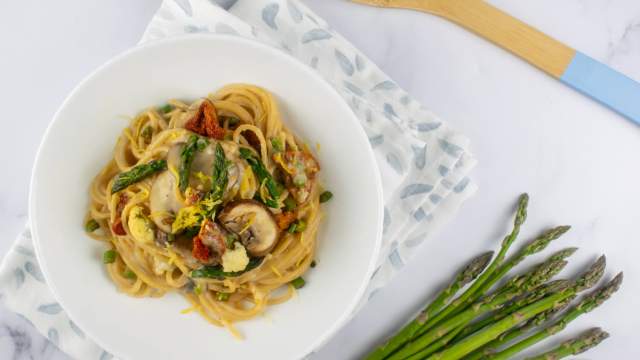 Vegetable alfredo with asparagus, mushrooms, and tomatoes in a creamy alfredo sauce.