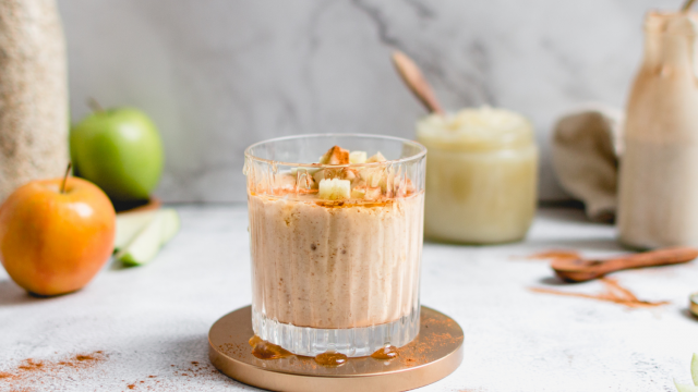 Apple banana smoothie with cinnamon, apples, bananas, and oats in a glass with apples on the side.