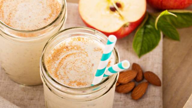 Apple Pie Smoothie in a mason jar with apples and almonds.