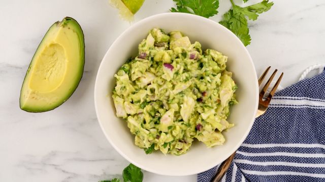 Avocado chicken salad with shredded chicken breast, avocados, lime juice, and cilantro in a bowl.