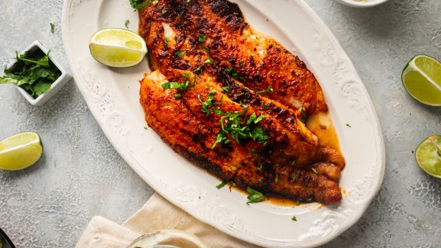 Blackened mahi mahi served with homemade blackening seasoning on a plate with fresh lime wedges.