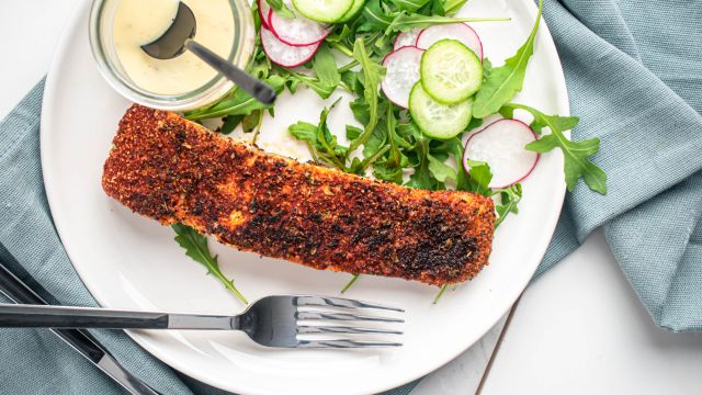 Blackened salmon with a homemade spice blend on a plate with salad.