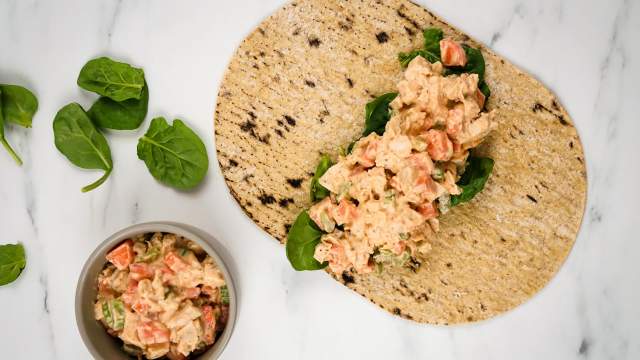 Buffalo ranch chicken wrap with celery, carrots, buffalo dressing, and ranch seasoning in a wrap with spinach.