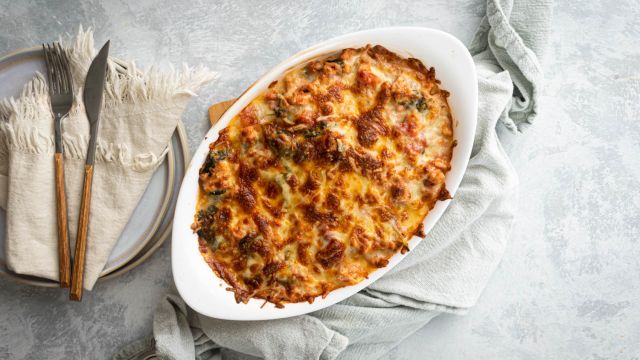 Cauliflower rice casserole with ground turkey, tomatoes, and spinach in a baking dish. 