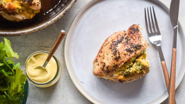 Stuffed chicken breasts with broccoli and cheddar on a plate with mustard on the side.