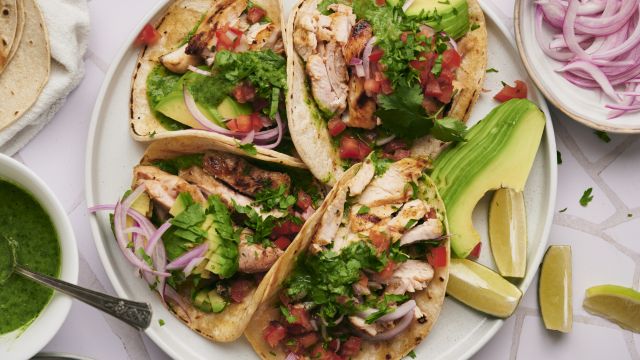 Chicken street tacos with grilled chicken thighs, fresh cilantro, onion, salsa, and lime served on corn tortillas.