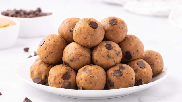 Chickpea cookie dough bites with canned chickpeas, peanut butter, maple syrup, chia seeds, and chocolate chips stacked on a plate.