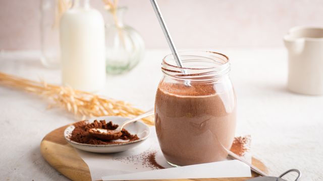 Chocolate breakfast shake with tofu, almond milk, and bananas in a mason jar with whipped cream.