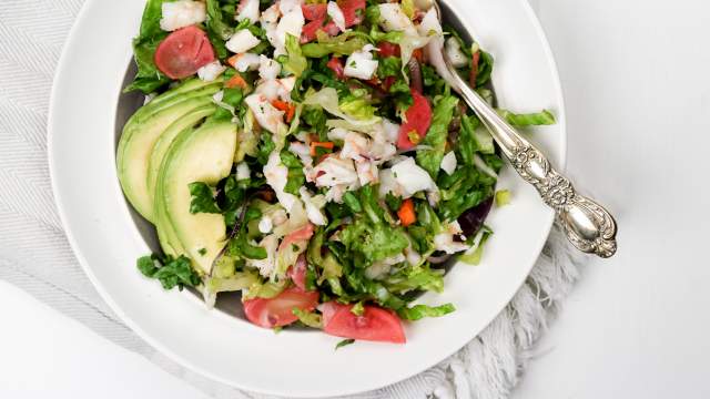 Chopped shrimp salad with fresh herbs, avocado, and a lemon vinaigrette in a bowll.