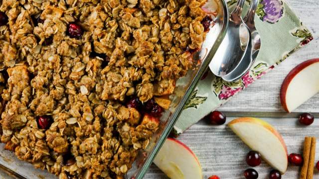 Cranberry Apple Baked Oatmeal with apple slices and fresh cranberries next to the dish.